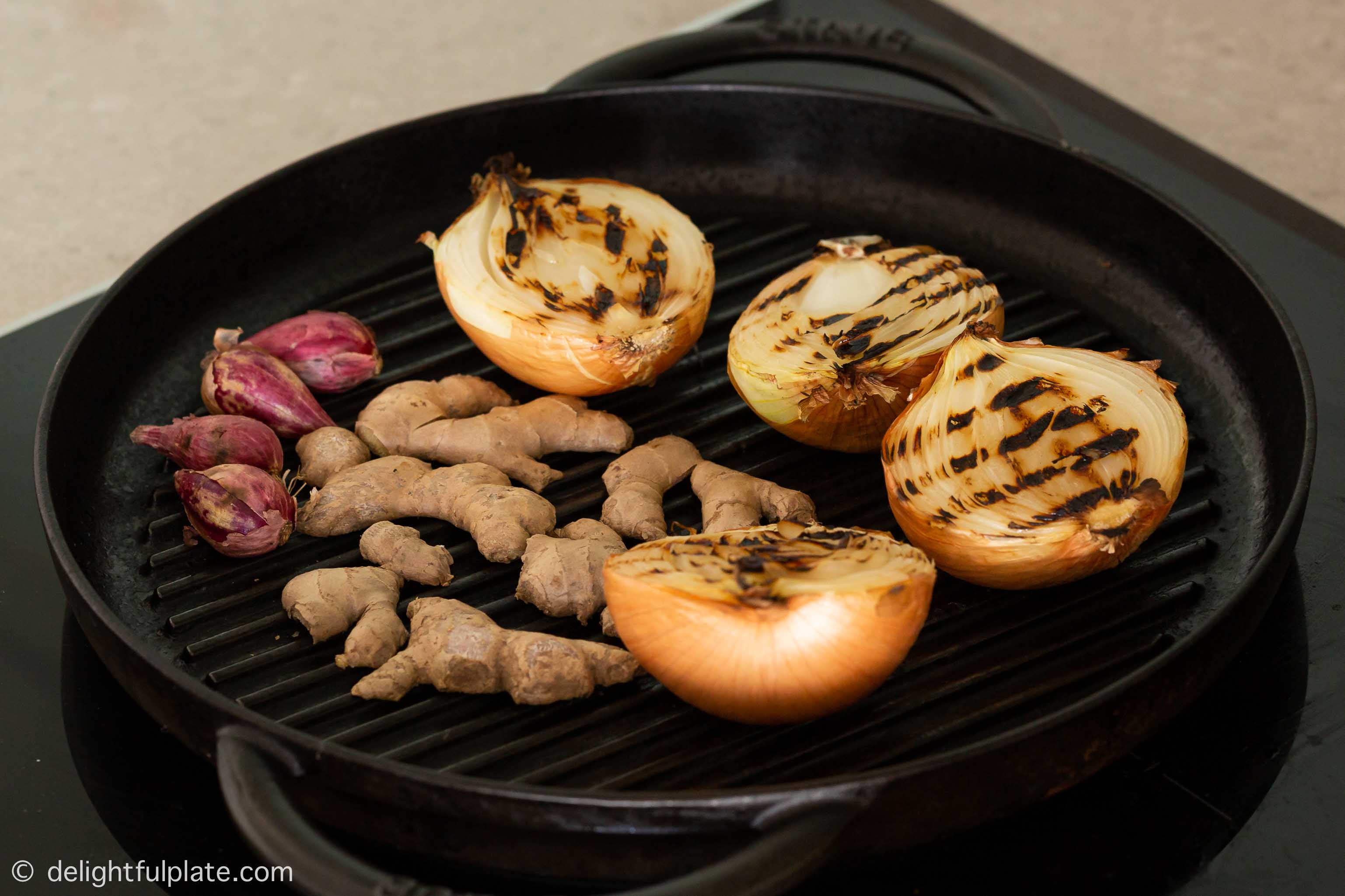 charring onion, ginger and shallot on a grill pan