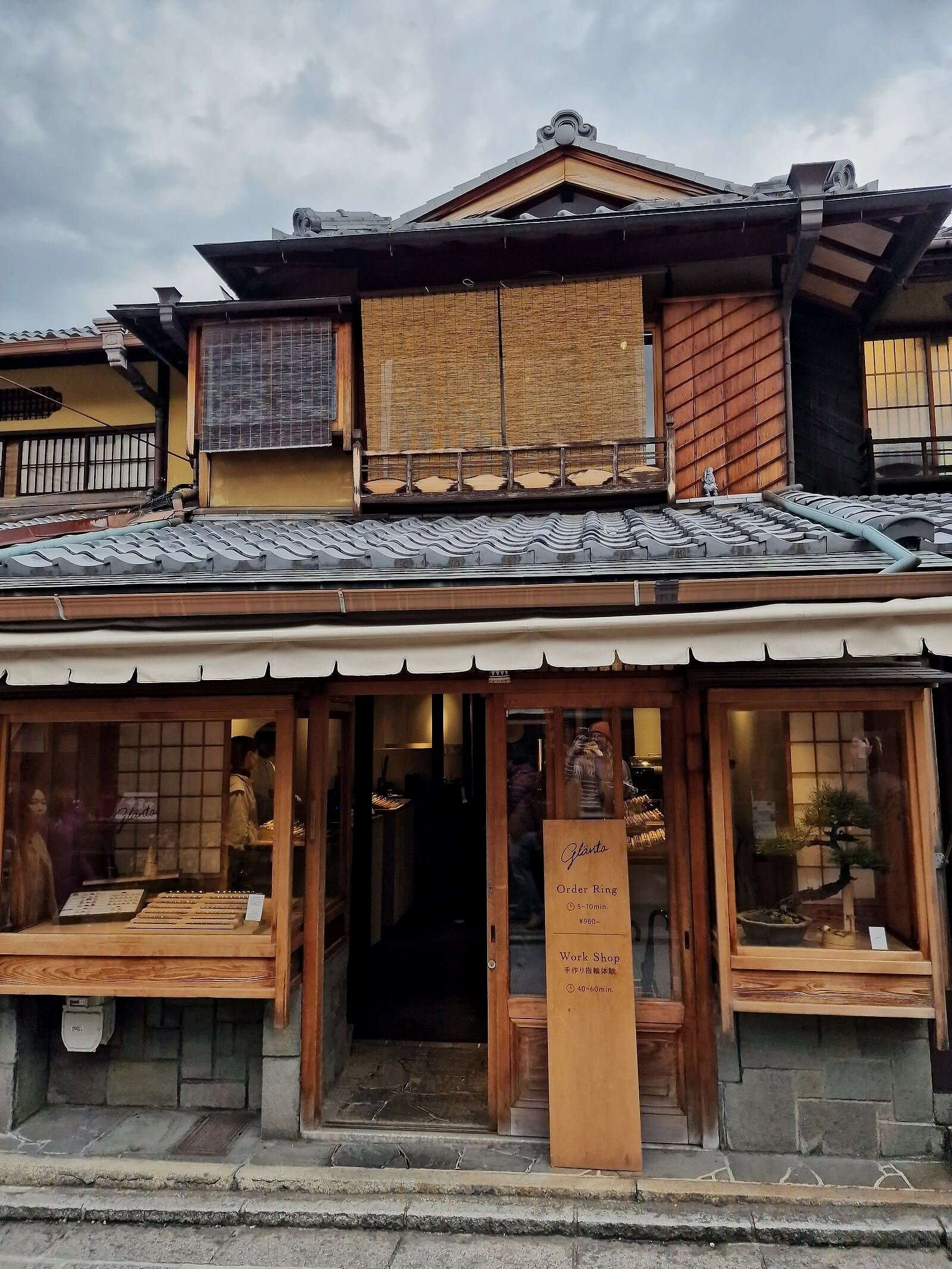 a traditional wooden japanese house, two storeys high with bamboo window covers