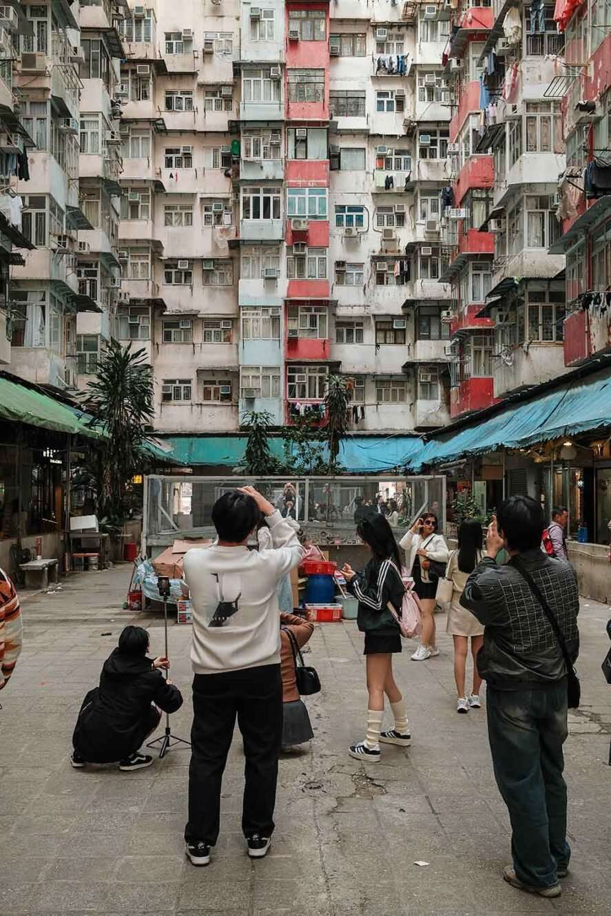 Tourists taking photos of the Monster Building in Hong Kong